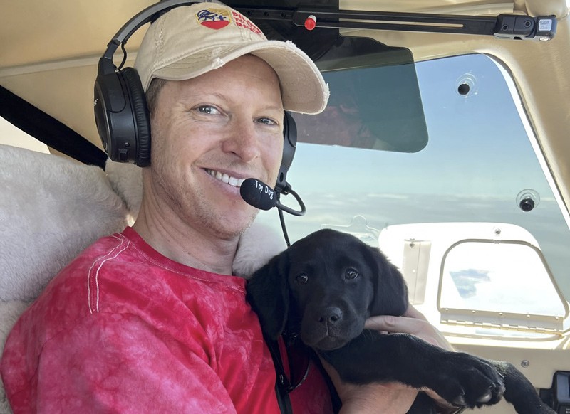 Micahel Schneider with pup on plane
